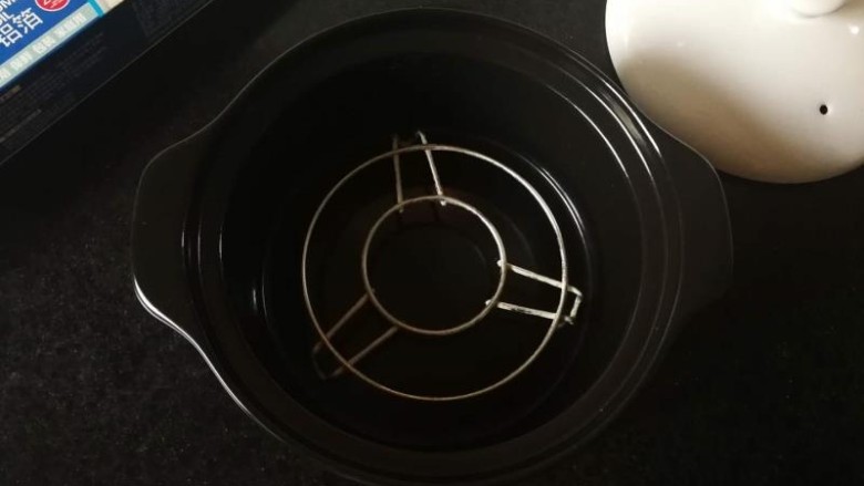 红酒什香草烤猪排,砂锅冲洗干净,擦干,放入烤架。建议放烤架,不放的话锡纸容易黏住锅底哦!