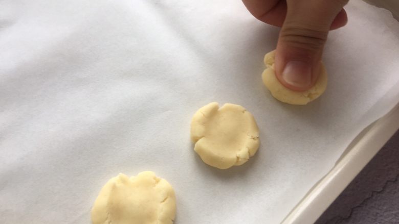 玛格丽特饼干,将小圆球放在烤盘里,用大拇指按扁,会出现自然的裂纹;