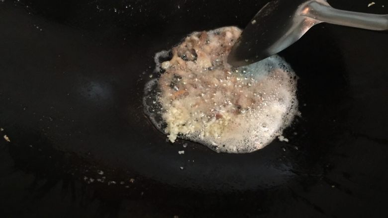 西兰花腊肠蛋炒饭,锅中再次热油,放入蒜蓉和咸肉,炒出香味。