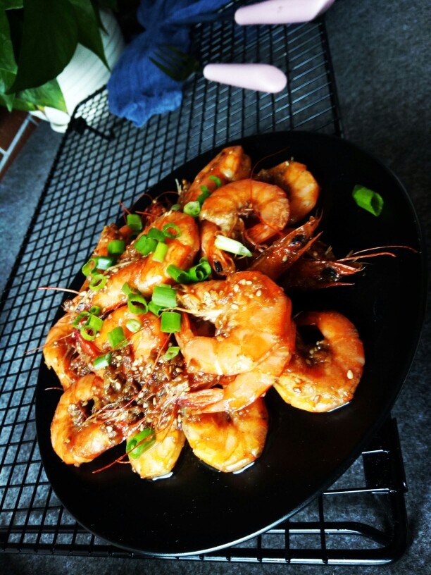 爆炒蒜蓉虾,把火开大，把虾倒入锅里快速翻炒，给盐，<a style='color:red;display:inline-block;' href='/shicai/ 721'>蚝油</a>，<a style='color:red;display:inline-block;' href='/shicai/ 718'>料酒</a>，还有酱油，继续翻炒至虾熟，放入白芝麻继续翻炒均匀后起锅，撒上葱花即可。