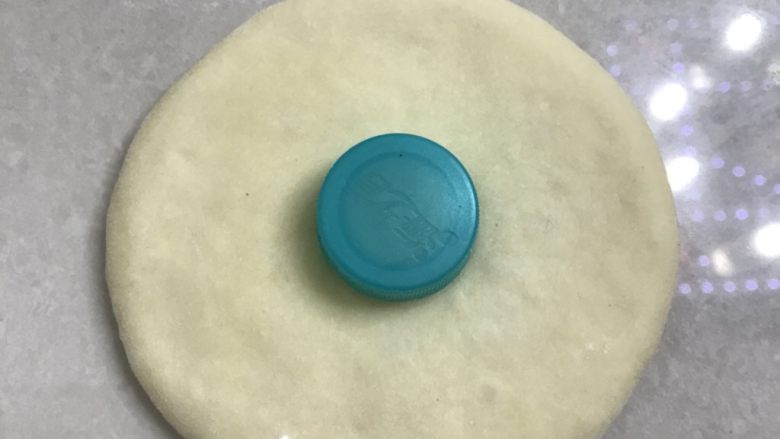 椰蓉花朵面包,找一个瓶盖,找一下中心位置轻轻按压。