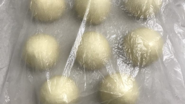 椰蓉花朵面包,收口朝下滚圆全部做完盖上保鲜膜,松弛10分钟。