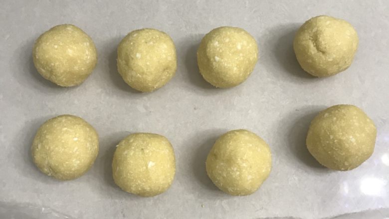 椰蓉花朵面包,这时从冰箱取出椰蓉馅,平均分成8份滚圆。
