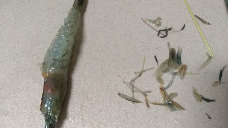 避风塘炒虾,首先处理虾,洗干净后,用剪刀剪掉虾脚和胡须,再剪开虾背部,取出虾线