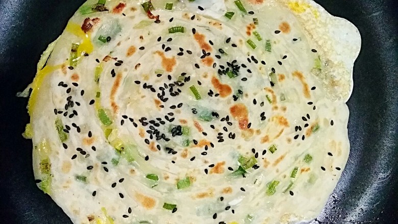 做饼+手抓饼,等鸡蛋半凝固时翻面,让鸡蛋面朝下,稍微一烙就可以出锅了。