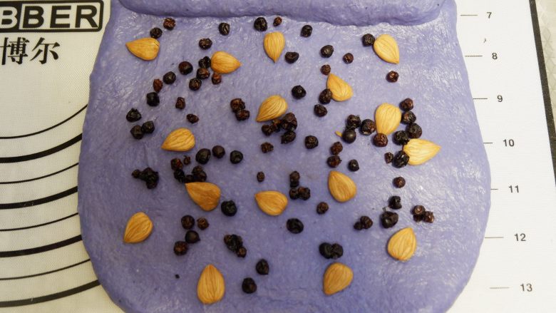 星空吐司(不用摔,不用搓,轻松出膜),剩余的面皮上平铺上杏仁和蓝莓干卷起来