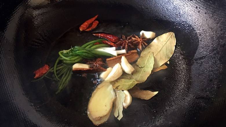 家常红烧小羊肉,放入葱姜蒜、桂皮、八角、香叶,爆香;
