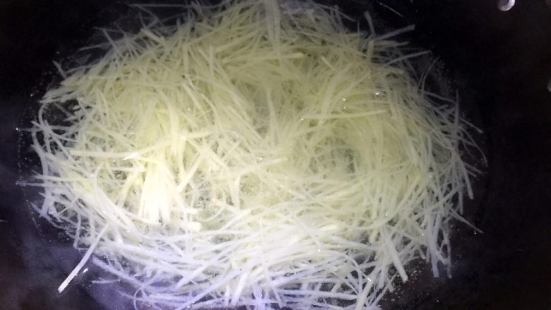 爽口土豆丝,锅内烧一大锅水,注意下面步骤很关键,水内滴两滴香油,以下步骤要连贯进行,不要拖泥带水,大火煮沸后倒入土豆丝---用筷子迅速搅散----盖上锅盖----关火,关火,让土豆丝在锅内焖一分钟