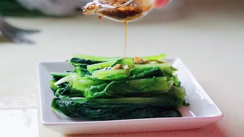 一菜二吃-凉拌爽脆莴笋叶,沥干水分的莴笋叶装入盘中,淋上调好的酱汁