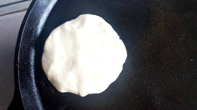 做饼+萝卜丝猪肉馅饼,轻轻压扁,放入涂上油的平底锅上。