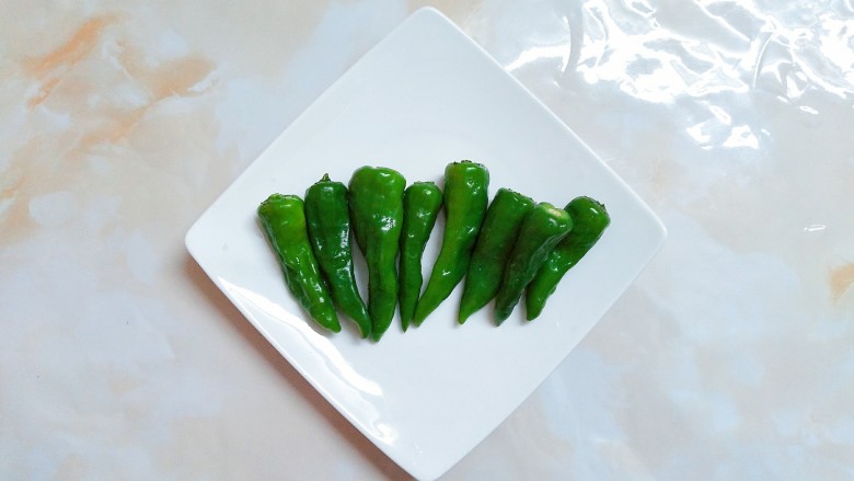小炒卤猪嘴肉,把青椒去蒂清洗干净!