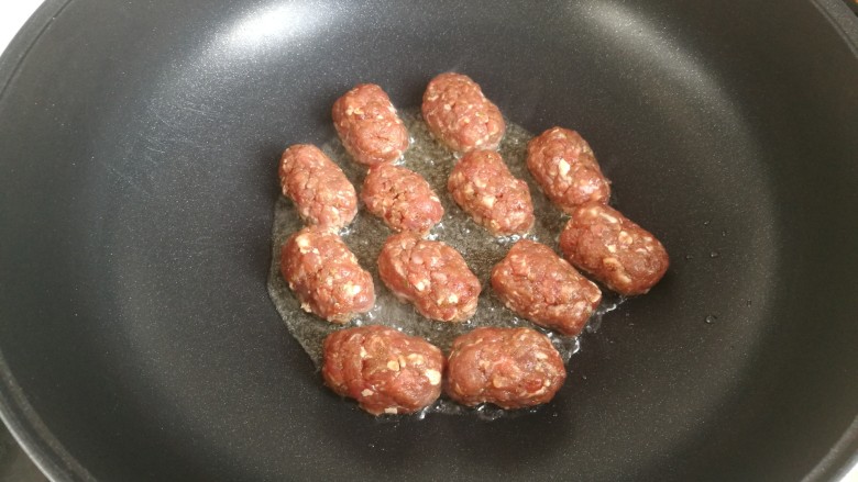 煎牛肉丸,五分热,把丸子摆在锅中,煎至一面上色