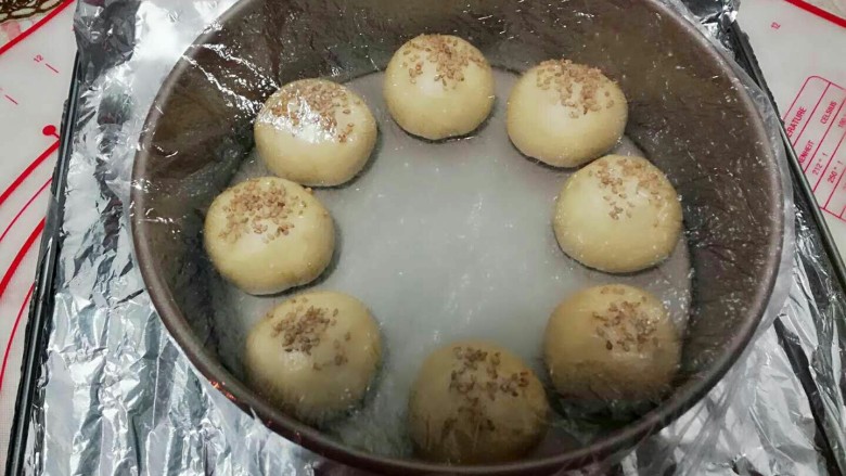 花环小汉堡,刷好后,盖上保鲜膜,放入烤箱中进行发酵。(为了保持烤箱里面湿度,最好放一盆温水)