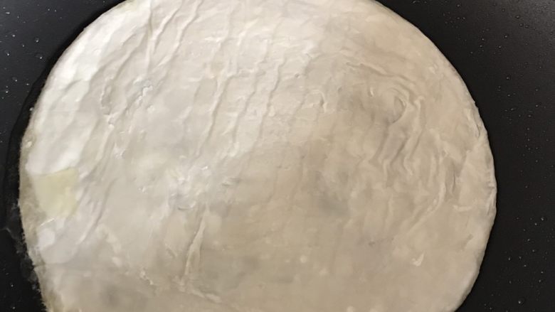 懒人版手抓饼,把饼皮前后的膜撕掉,放进不粘锅小火煎