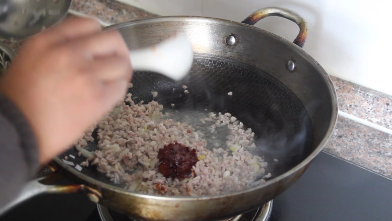 蚂蚁上树的做法,再下入葱姜沫炒出葱香味后加一勺豆瓣酱炒出红油。