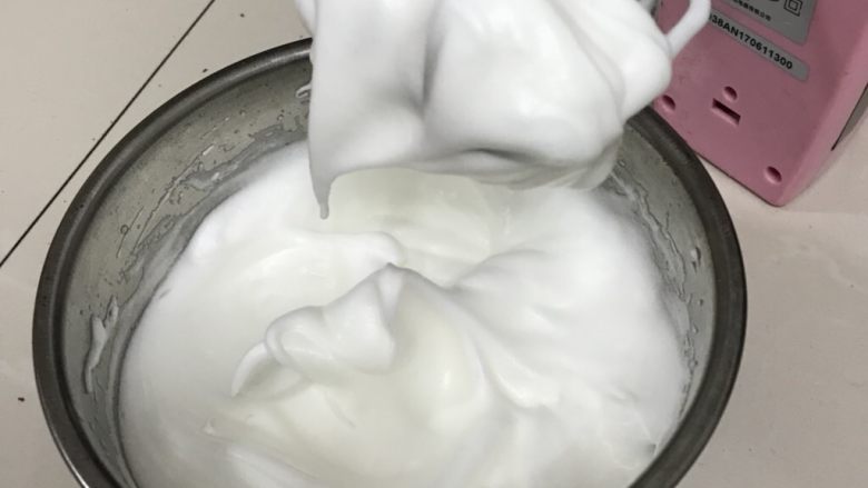 水果生日蛋糕,中高速打至性发泡,拿起打蛋头有大弯钩状态全部加入白糖。