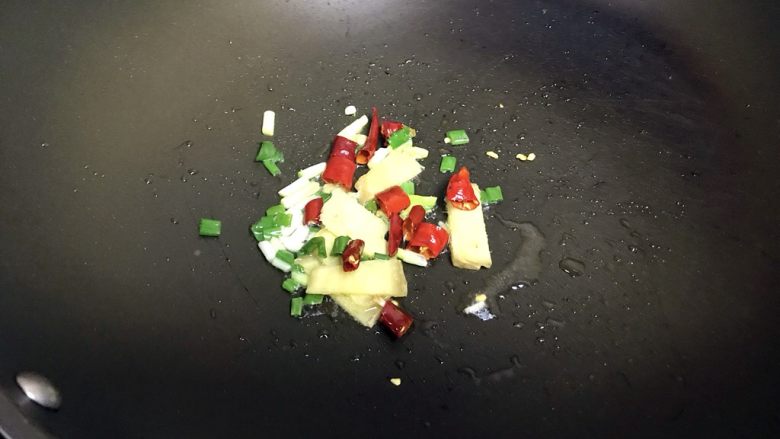 花菜烧肉,起油锅,油热放入葱姜红辣椒炒香