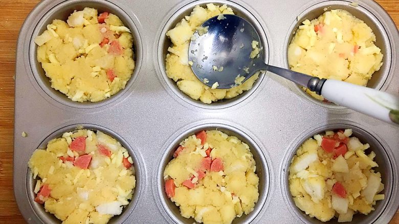 创意料理の马苏里拉奶酪芝士馒丁水果挞,取不沾六连烤盘,用勺子把混合物装进去,并且轻轻压几下