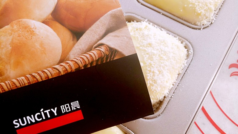椰蓉小餐包,为了美观建议用一张小纸板遮住面包的一半,均匀撒上酥粒。