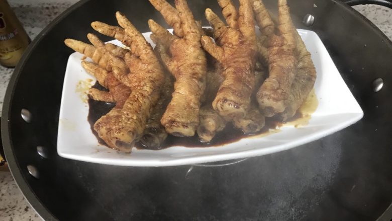 虎皮凤爪,锅里放水,放上三脚架,鸡爪放入锅内蒸