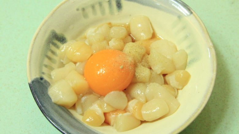 咸蛋黄扇贝丁,扇贝丁清洗干净滤干水,倒入小勺料酒,加白胡椒粉和盐调味