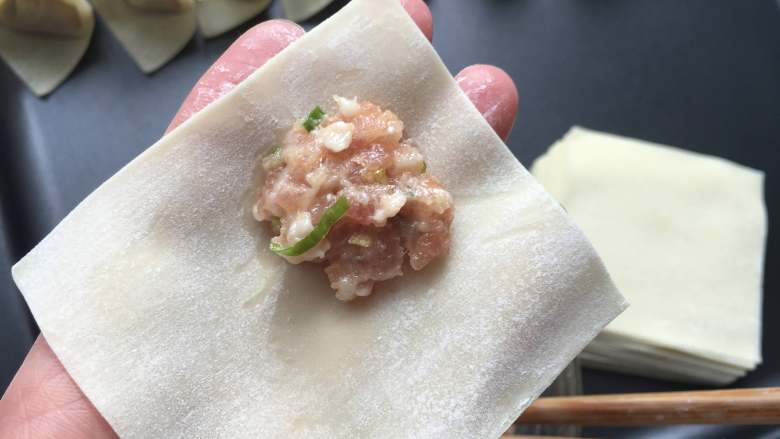 红油抄手,开始包抄手,取一张馄饨皮,将肉馅放在一个角上