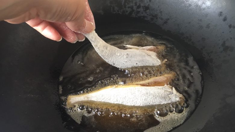 下酒小菜 红烧小黄花鱼,锅里放适量的油,油5、6成热时拎着鱼尾轻轻的贴着油面放到锅里。