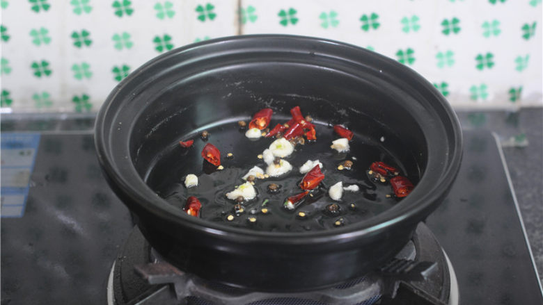 水煮牛肉,酒精锅内胆加入,放入少许油,爆香花椒、干辣椒段、蒜末,煸炒出香味