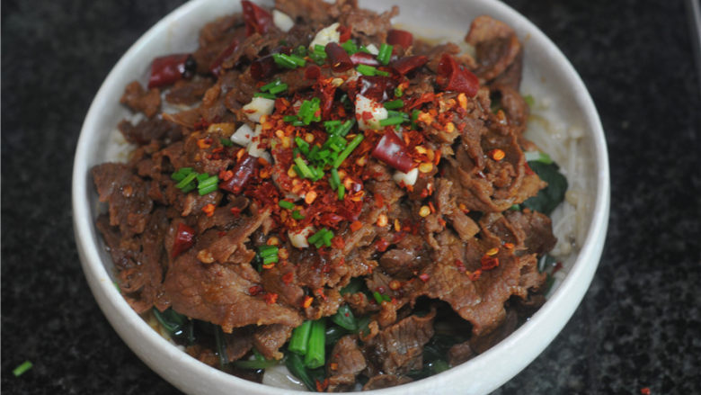 水煮牛肉,捞出牛肉,铺在青菜上,撒上葱花、<a style='color:red;display:inline-block;' href='/shicai/ 761'>辣椒粉</a>、蒜末