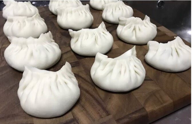 多汁牛肉蒸饺,重复擀皮-舀馅儿-包饺子的步骤,把剩下的饺子包完,尽量皮光肉光。