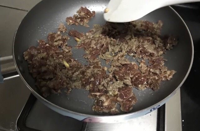 多汁牛肉蒸饺,在等待醒面的过程中,就可以炒馅儿啦。锅里倒入适量植物油,倒入腌制好的牛肉末,迅速翻炒至八成熟,用刮刀搅散。大约剩1/5没有变色即可起锅。