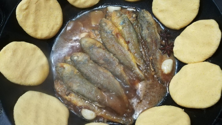 家常小黄鱼贴饼子,把面团一个一个按在锅边上,中小火,盖上盖子。