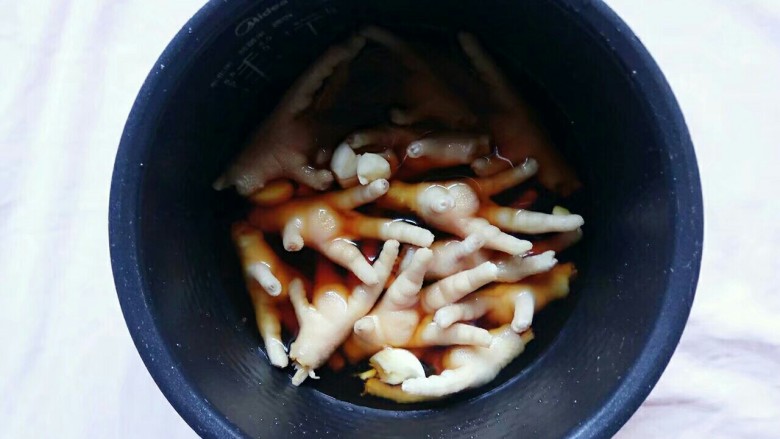 电饭锅+卤凤爪,加好盐和酱油后加入水,水平敷过凤爪即可,然后搅拌几下