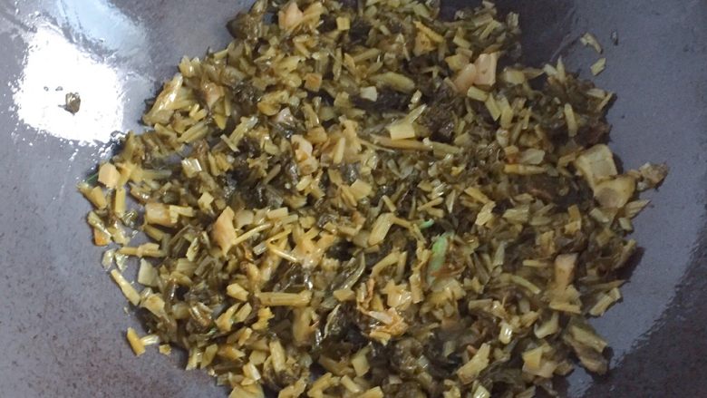 咸菜炒冬笋,另起锅倒入适量油,放入剩余的一半葱白炒香,放入咸菜煸炒。