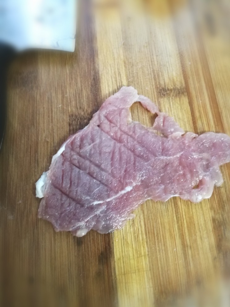 里脊肉烤菜花,猪肉切大片后,用刀背拍松