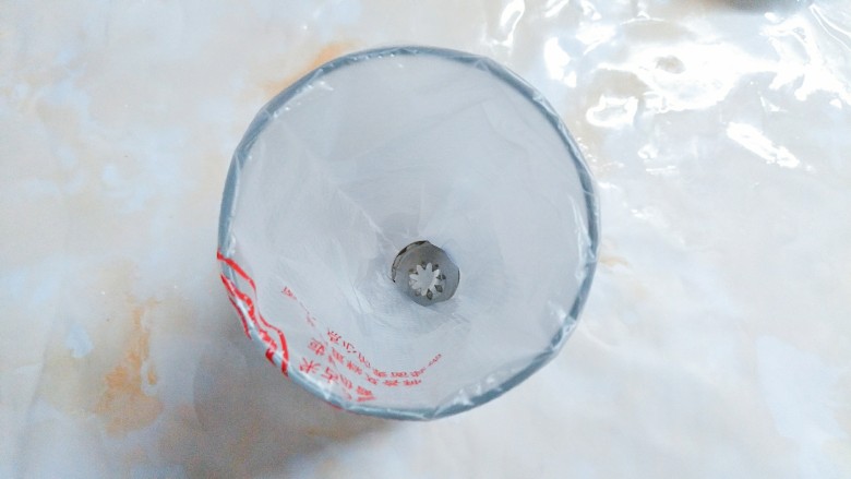 鲜草莓,蓝莓溶豆,准备好一个八齿裱花嘴和一个裱花袋,装入一个较高的杯子里!以便拌好的蛋白可以很快放入裱花袋里,进行挤花!
