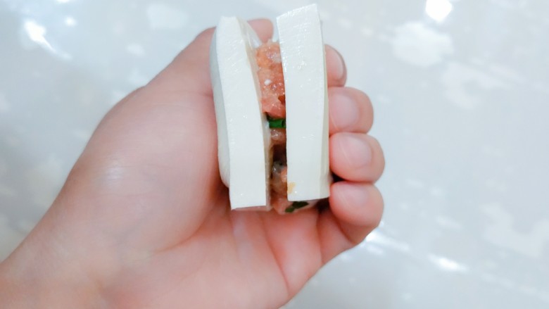 汤汁肉夹豆腐,将腌制好的肉夹在豆腐中间。
