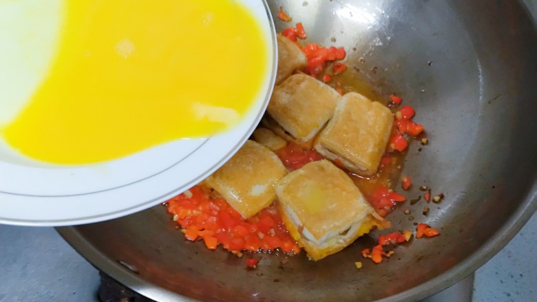 汤汁肉夹豆腐,待红辣椒丁断生后,豆腐块放进去,把水淀粉也放进去。