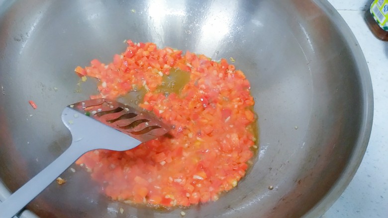 汤汁肉夹豆腐,豆腐盛起来之后,锅里还有很多油,倒掉一点,留一些,下姜末蒜末,和红辣椒丁翻炒。