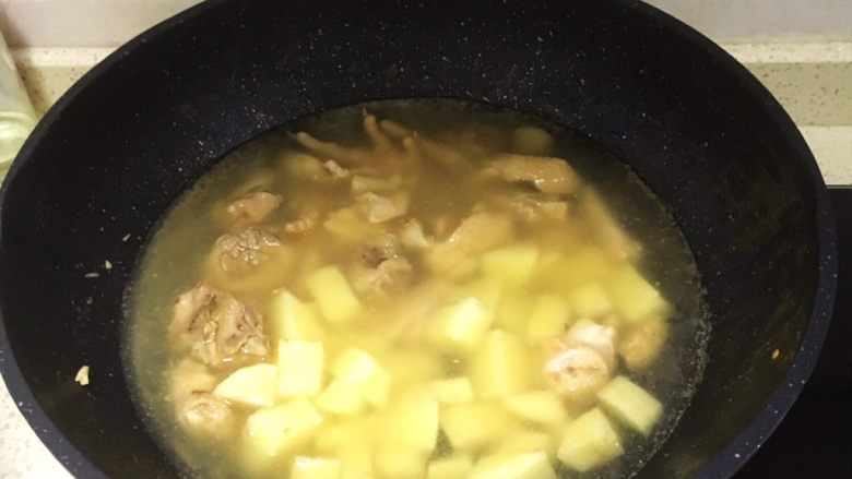 咖喱土豆鸡,倒入土豆,翻炒一下,倒入水刚好淹没过土豆,转中火盖上锅盖焖。