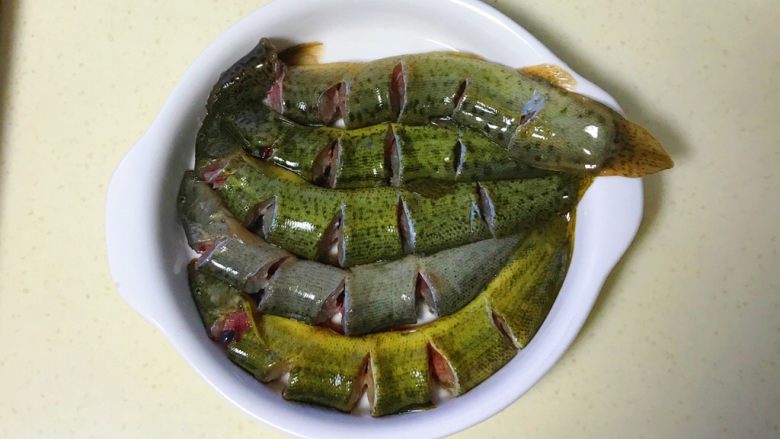 咸肉蒸黄斑泥鳅,全部剪好,在盘子里依次排好