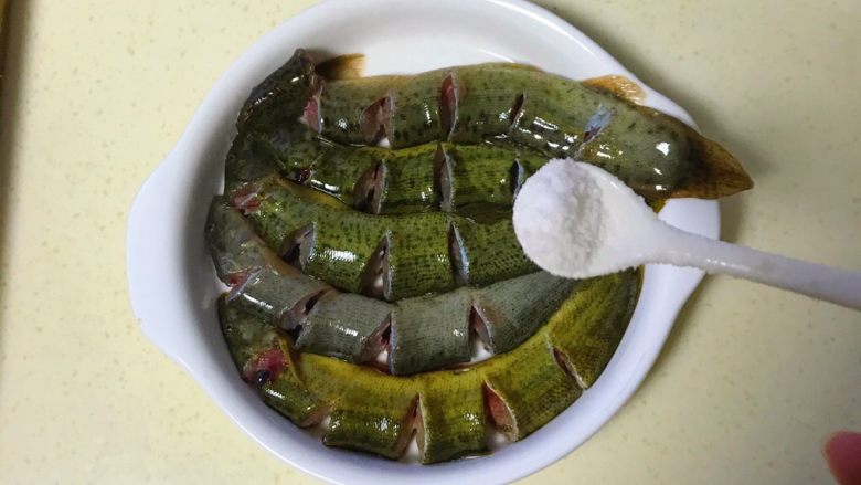 咸肉蒸黄斑泥鳅,把盐均匀撒在泥鳅上