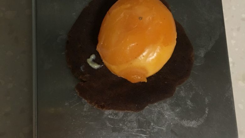 蛋黄酥,油皮松弛期间开始做馅团,将20克左右的红豆沙揉成圆片加入鸭蛋黄称量40克。咸鸭蛋直接使用不用提前烤熟,口感好、不分层。