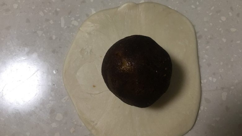 蛋黄酥,将馅团放入油皮里。