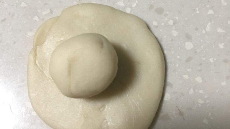 蛋黄酥,油皮团擀成圆形皮,将油酥团放入油皮面皮里。