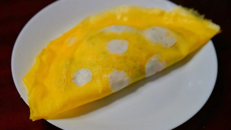 三文鱼波点蛋包饭,包入炒饭,对折,用剩余蛋液封口