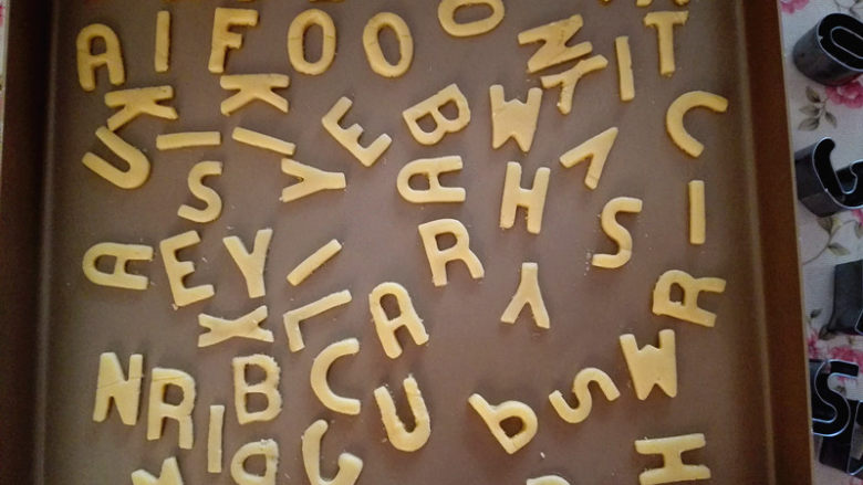 字母饼干,再把按压出的字母转移到不粘烤盘上,