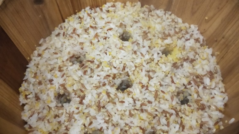 五谷杂粮木桶饭,蒸汽上来后,用筷子把米饭戳几个洞,以便蒸汽更好地上来,熟得更均匀。大约蒸制15-20分钟。