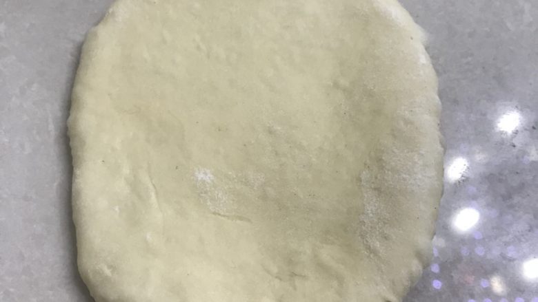 蜂蜜肉松面包卷,取一个面团光滑面在上,从中间向两头擀开。