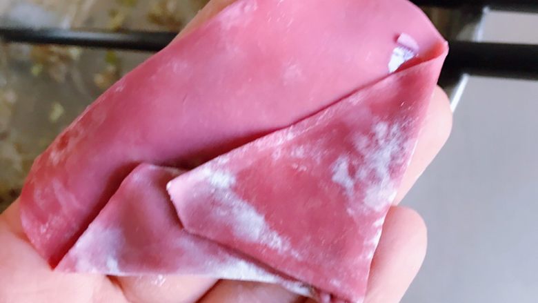 馄饨的四种包法,用清水沾湿左边的馄饨皮,然后向左边叠过来;